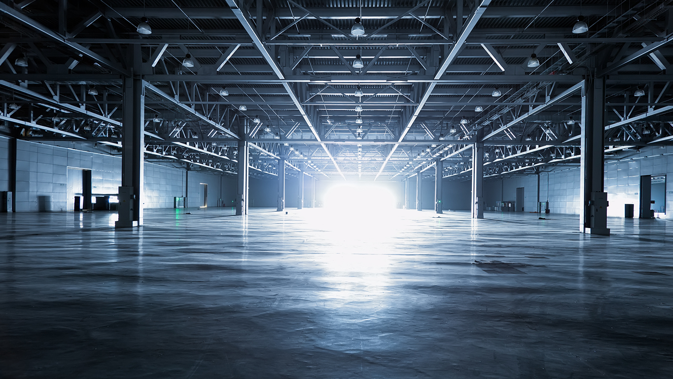 Image of an empty warehouse with a bright light at the end, symbolising the future of AI innovation.
